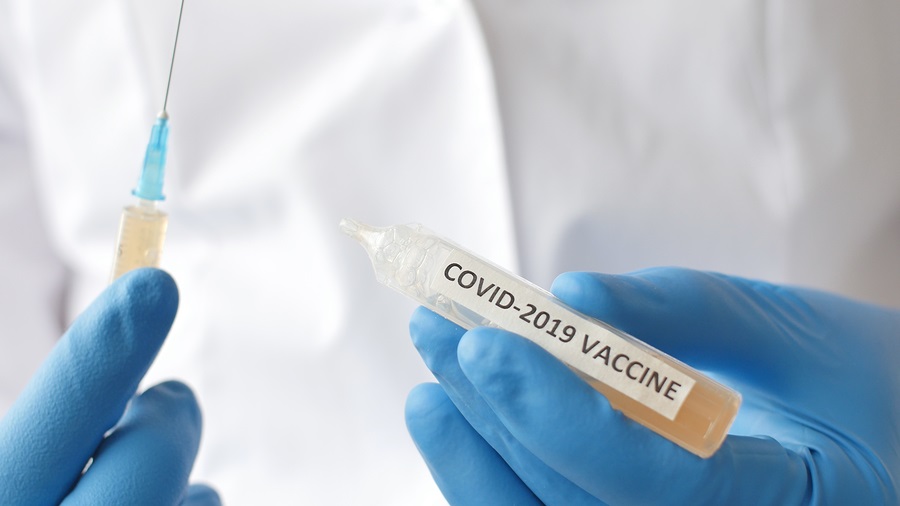 Medical doctor or laborant holding tube with nCoV Coronavirus vaccine for 2019-nCoV COVID virus. 